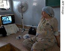 An elderly Lebanese woman watches Hezbollah leader Hassan Nasrallah say his group would abide by a UN ceasefire resolution 