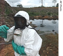 Waste removal experts work to remove hazardous black sludge from a garbage dump in Abidjan, Ivory Coast, Sunday, Sept. 17, 2006