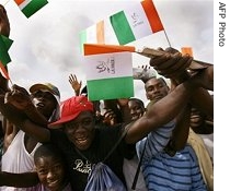 People wave Ivorian flags reading 'Peace' 21 April 2007 at Youpougon sport complex, in Abidjan during a jonit 