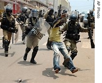 Ugandan riot police arrest a protestor as they disperse a crowd protesting against government plans to allocate forest land to a sugar company in Kampala, 12 Apr 2007