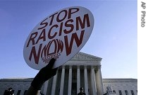 A demonstrator holds up a sign in front of the Supreme Court as court heard arguments on lawsuits by parents in Louisville and Seattle challenging policies that use race to help determine where children go to school, 04 Dec 2006 file photo