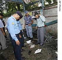 Nepalese police officials inspect a blast site at a busy market place in Kathmandu, Nepal, 02 Sept 2007