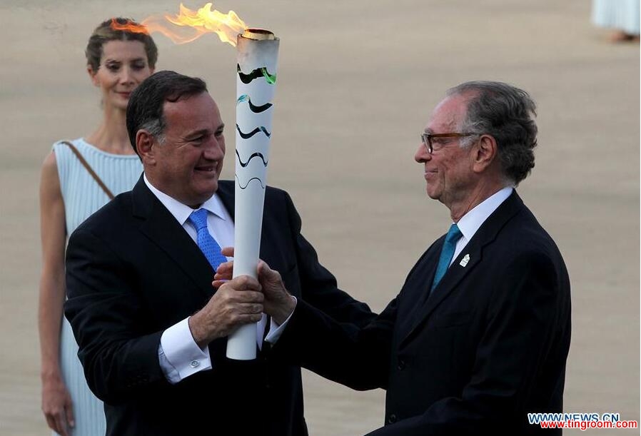 ATHENS, April 28, 2016 (Xinhua) -- Carlos Nuzman(R), the President of the Organizing Committee for the "RIO 2016" Olympic Games, receives the torch from Spyros Capralos, the President of HOC (Hellenic Olympic Committee), during the handover ceremony at Panathenaic Stadium in Athens, April 27, 2016. (Xinhua/Marios Lolos)