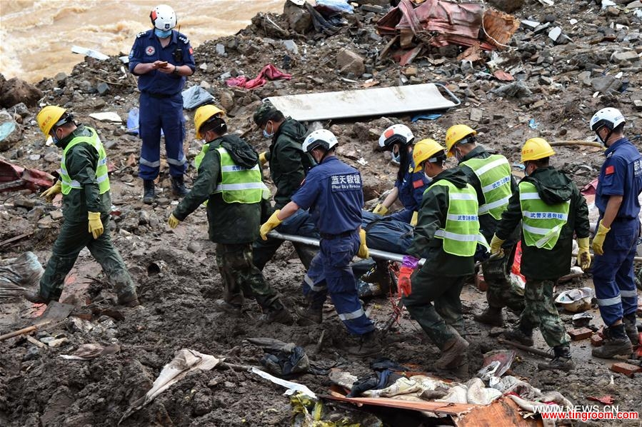 Rescuers carry a body of victim at the landslide site in Taining County, southeast China