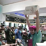 A store clerk holds up a Wii box on its first day available for sale