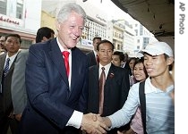 Bill Clinton shakes hands with a young Vietnamese on a street in Hanoi 6 Dec 2006
