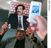 An Egyptian man holds a photograph of Iraq's late president Saddam Hussein during a condolences service held at the local lawyers syndicate in Cairo, 3 Jan 2007