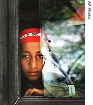 A rescued child laborer looks out from the window of a bus as he arrives to participate in a march against child trafficking, in New Delhi, India, 22 Mar 2007
