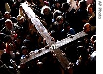Catholic pilgrims carry a large cross in the Church of the Holy Sepulcher, traditionally believed to be the site of the crucifixion and burial of Jesus Christ, during the Good Friday procession and the Way of the Cross, in Jerusalem's Old City