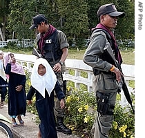 A Thai Muslim girl (far L) salutes a soldier on patrol while heading back home along with friends in Thailand's insurgency-torn southern Narathiwat province, 06 June 2007