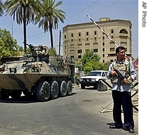 Australian troops aboard an armoured personnel vehicle pass by a checkpoint guarded by an Iraqi policeman at a junction near the Australian embassy in Baghdad (File)