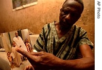 Zubairu Shaba shows a picture of one of his kids tested with the meningitis epidemic experimental drug and now suffering brain damage in Kano, Nigeria, 19 July 2007