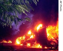 Trucks set ablaze by angry residents go up in flames in Agra, India, early Wednesday, 29 Aug 2007 <br />