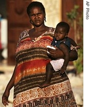 A Sudanese refugee woman carries her baby outside a private home where she and others are temporarily being housed in Kadesh Barnea, Israel, 19 Aug. 2007